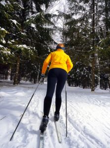 A young woman cross country skiing in a wonderful forest.