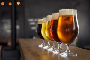 Glasses with different sorts of craft beer on wooden bar on brewery tours