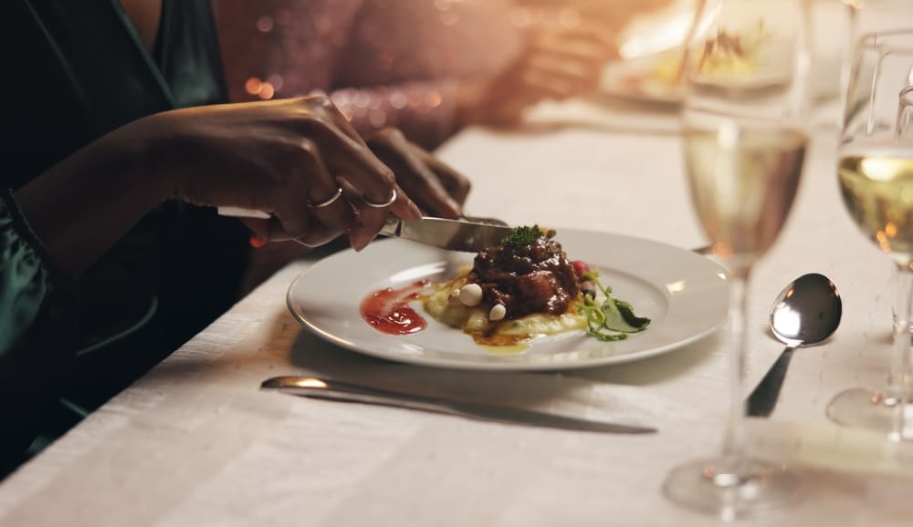 Woman cuts into her gourmet meal at one of the downtown Duluth restaurants.